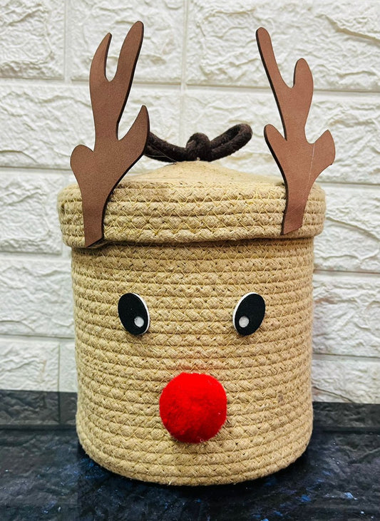 Decorative basket shaped like a reindeer with antlers and a red nose on a stone surface.